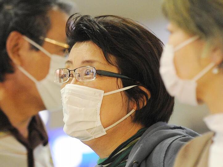 Mundschutz aus Angst vor einer möglichen Infektion: Japanischen Touristen auf dem Flughafen in Frankfurt am Main.