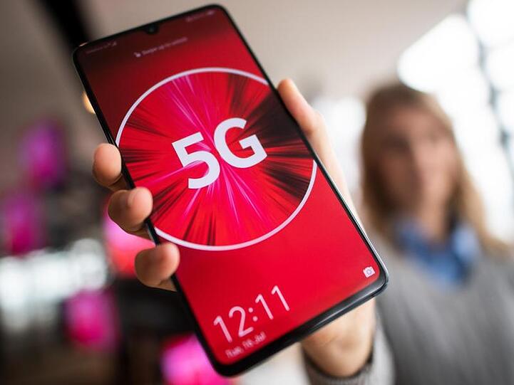 Eine Vodafone-Mitarbeiterin hält ein 5G-Smartphone in der Hand. Vodafone treibt mit einer Tarif-Offensive das neue 5G-Mobilfunknetz voran.