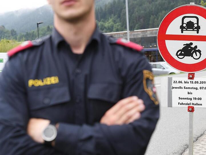 Ein Polizist steht vor einem Schild, das auf die Sperrung für den Verkehr mit Fahrziel Italien hinweist. Foto: Angelika Warmuth/Archivbild