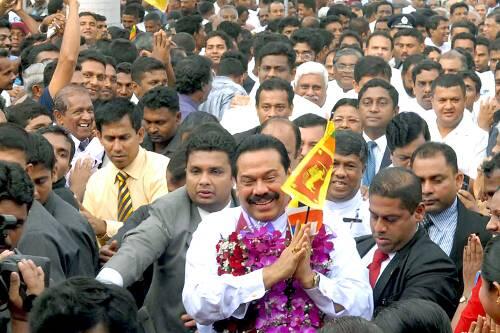 Ministerpräsident Mahinda Rajapaksa (mit Blumen und Fahne) lässt sich auf den Straßen für den blutigen Sieg feiern.