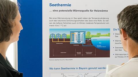 Besucher der Abschlussveranstaltung betrachten das Schema einer Seethermie-Anlage.