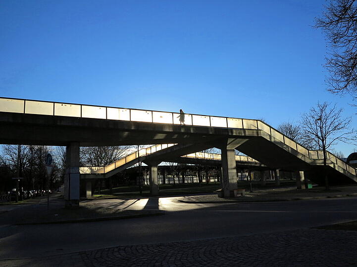 Interessante Schattenspiele: Fußgänger und Radler auf der Neuperlacher Sonnenbrücke.