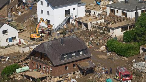 Rettungskräfte sind nach dem Hochwasser im Einsatz. Die Flut hat auch hier zahlreiche Häuser zerstört.