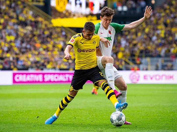 Dortmunds Thorgan Hazard und Augsburgs Michael Gregoritsch (l-r.) im Zweikampf um den Ball. Foto: Guido Kirchner