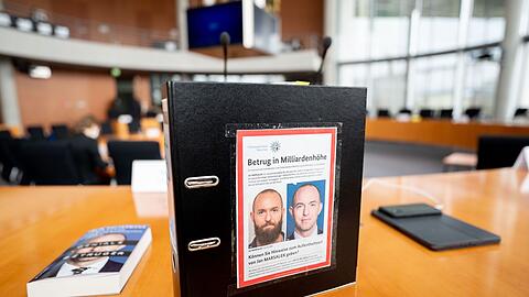Ein Aktenordner mit Fahndungsfotos von Jan Marsalek im Untersuchungsausschuss des Bundestags. Ist der frühere Wirecard-Vorstand in Russland?