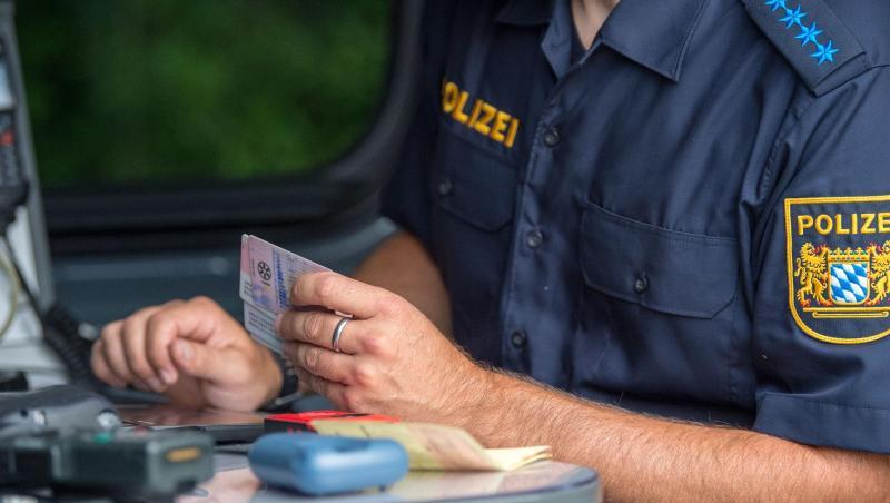 Ein Beamter der bayerischen Grenzpolizei kontrolliert am Grenzübergang Kirchdorf Dokumente von Autofahrern. Ein Beamter der bayerischen Grenzpolizei kontrolliert am Grenzübergang Kirchdorf Dokumente von Autofahrern.