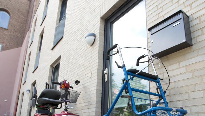 Ein Rollator und ein Elektromobil stehen vor einer Seniorenwohnung. Ein Rollator und ein Elektromobil stehen vor einer Seniorenwohnung.