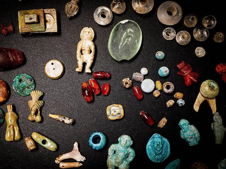 Amulette, Edelsteine, Puppen aus der Truhe.
