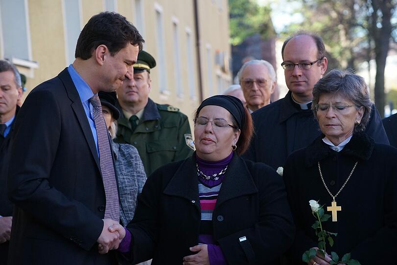 Staatssekretär Eisenreich (links) drückt Pinar Kilic (Mitte), der Witwe des vierten NSU-Opfers, tröstend die Hand. Im Hintergrund: Herzog Franz von Bayern.