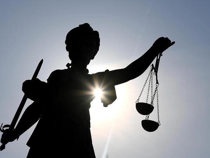 Die Statue der Justitia steht mit einer Waage und einem Schwert in der Hand. Foto: Arne Dedert/dpa/Archivbild