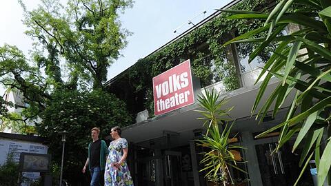 Ein Mann und eine Frau verlassen das Volkstheater. Foto: Tobias Hase/dpa/Archivbild