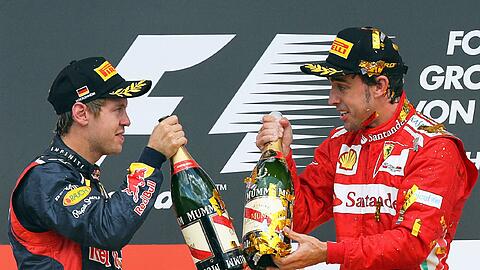Sebastian Vettel und Fernando Alonso prosten sich mit Champagnerflaschen zu.