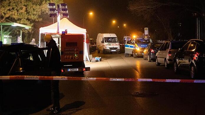 Polizeibeamte inspizieren den abgesperrten Tatort in der Nähe einer Haltestelle in Augsburg.