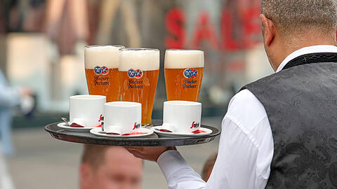 Ein Ober serviert Bier. Das wird deutlich teurer.