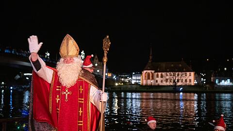 Von zahlreichen Fackelschwimmern begleitet ist der Nikolaus in Bernkastel-Kues in einem Ruderboot &uuml;ber die Mosel gekommen.