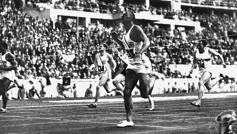 Jesse Owens (rechts) läuft im 100-Meter-Endlauf (10,3 Sekunden) bei den XI. Olympischen Sommerspielen in Berlin als Erster durchs Ziel. Jesse Owens (rechts) läuft im 100-Meter-Endlauf (10,3 Sekunden) bei den XI. Olympischen Sommerspielen in Berlin als Erster durchs Ziel.