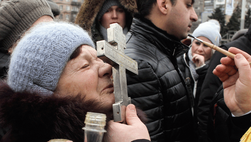 Ein orthodoxer Priester segnet Gläubige in der Stadt Mariupol: Die Welt hofft auf eine friedliche Lösung der Ukraine-Krise. Ein orthodoxer Priester segnet Gläubige in der Stadt Mariupol: Die Welt hofft auf eine friedliche Lösung der Ukraine-Krise.
