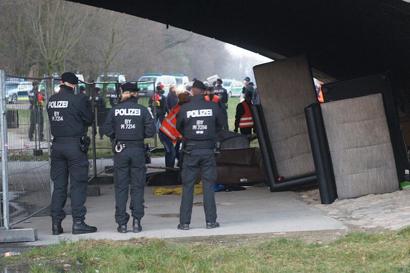 Unter Polizeiaufsicht wird das Lager geräumt, alle Habseligkeiten werden in einen Container geworfen.