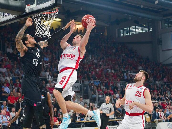 Brose Bambergs Fabien Causeur (M) und Leon Kratzer (r) kämpfen mit Bonns Julian Gamble (l) um den Ball. Foto: Nicolas Armer/Archiv