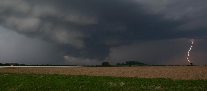 Eine Gewitterfront zieht am 13.05.2015 bei Bad Krozingen (Baden-Württemberg) über ein Feld.