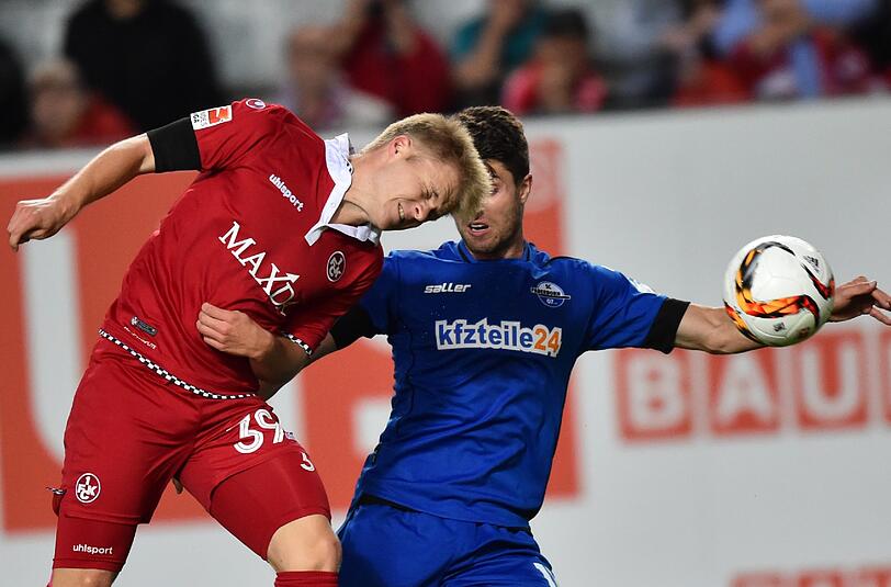 Kaiserslauterns Jean Zimmer (l) und Paderborns Moritz Stoppelkamp kämpfen um den Ball.