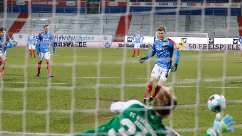 Alexander Mühling (r) von Holstein Kiel verwandelt einen Elfmeter gegen Würzburgs Torwart Hendrik Bonmann.