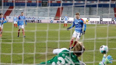 Alexander Mühling (r) von Holstein Kiel verwandelt einen Elfmeter gegen Würzburgs Torwart Hendrik Bonmann.