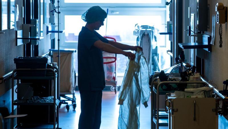 Eine Krankenschwester legt auf einer Corona-Isolierstation Schutzkleidung an. Eine Krankenschwester legt auf einer Corona-Isolierstation Schutzkleidung an.