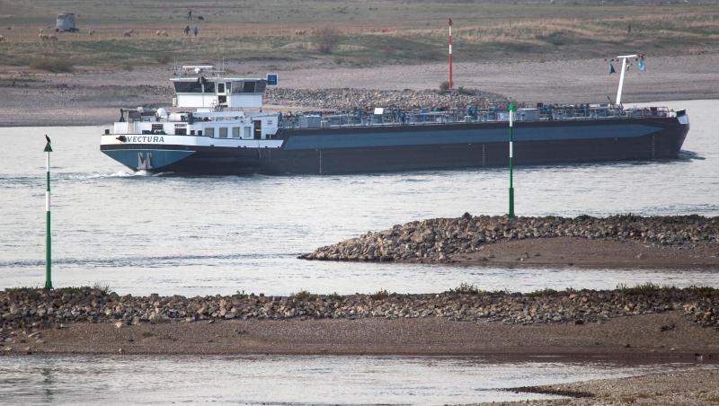 Ein Tankschiff fährt bei Niedrigwasser zwischen trocken gefallenden Buhnen auf dem Rhein. Ein Tankschiff fährt bei Niedrigwasser zwischen trocken gefallenden Buhnen auf dem Rhein.