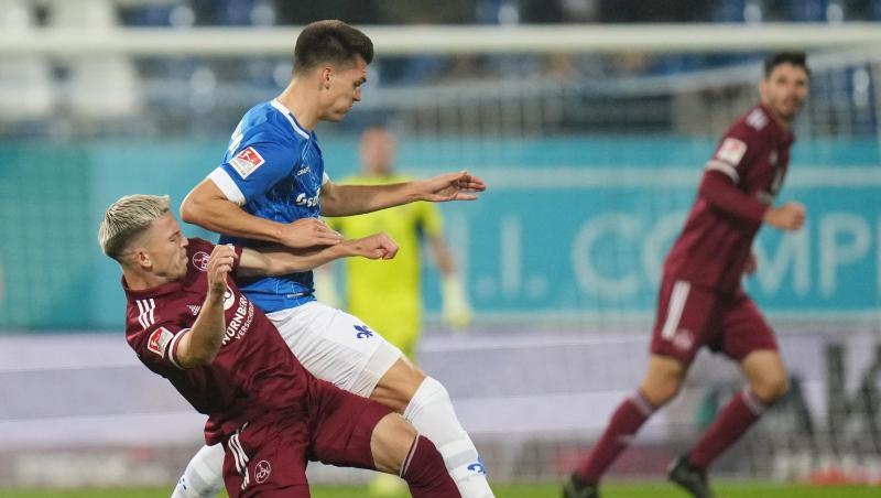 Nürnbergs Lino Tempelmann (l) und Darmstadts Mathias Honsak kämpfen um den Ball.