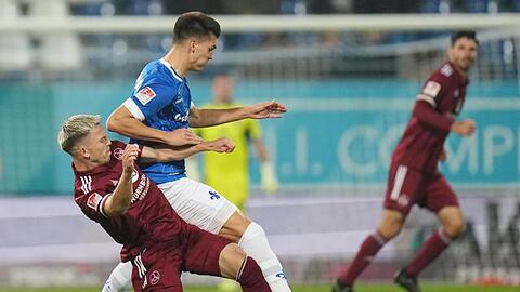 Nürnbergs Lino Tempelmann (l) und Darmstadts Mathias Honsak kämpfen um den Ball.