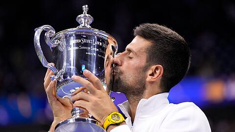 Novak Djokovic küsst die US-Open-Trophäe.