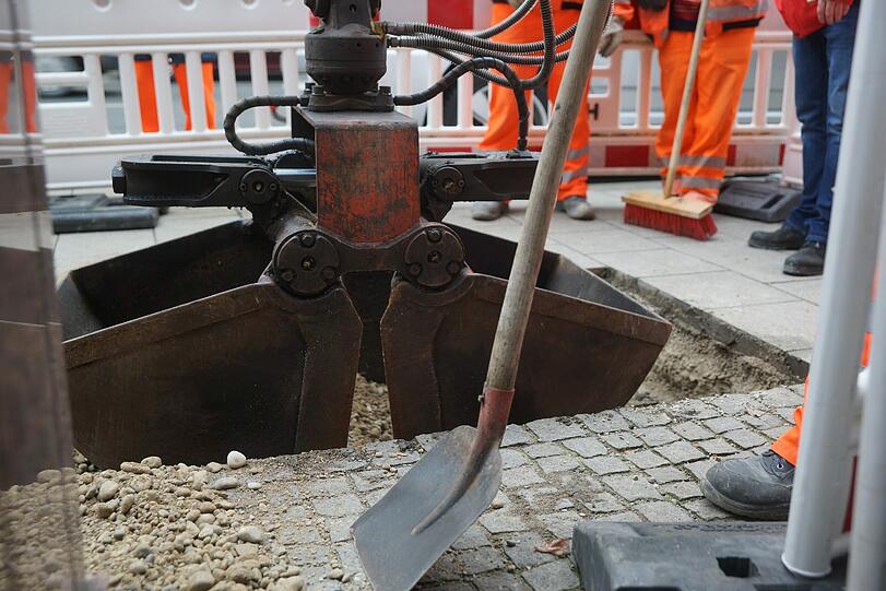 Mitarbeiter des Baureferats verfüllen den Schacht mit Kies und Beton.