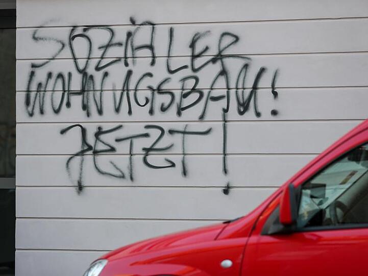 Graffiti "Sozialer Wohnungsbau! Jetzt!" befinden sich an einem neuen Mietshaus einer Wohnungsbaugenossenschaft. Foto: Jan Woitas/Archivbild