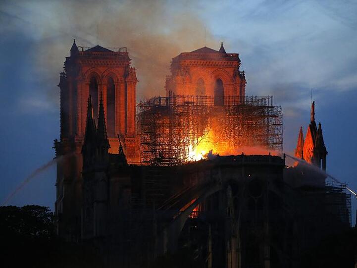 Ein Feuerwehrmann (r) versucht, das Feuer in der Kathedrale Notre-Dame zu löschen.