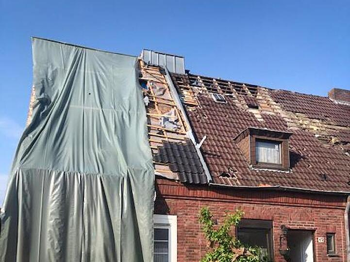 Der schwere Sturm deckte Dächer ab und ließ ein Auto wie Spielzeug durch die Luft fliegen.