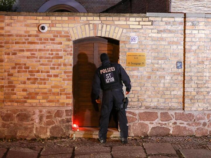 Ein Polizist inspiziert den Eingang der Synagoge in Halle.