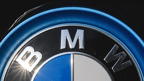 Die Sonne spiegelt sich in einem Logo des Autoherstellers BMW.