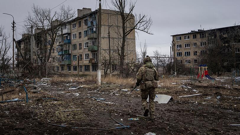 Ein ukrainischer Marinesoldat geht in Wuhledar an zerstörten Wohnblocks vorbei. Ein ukrainischer Marinesoldat geht in Wuhledar an zerstörten Wohnblocks vorbei.