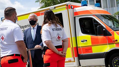 Bayerns Innenminister Joachim Herrmann (Mitte) im Gespräch mit BRK-Notfallsanitäter Martin Noß und Rettungsassistentin Marie Praß-Cuenca.