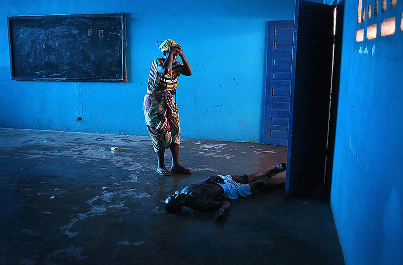 Eine Frau in Monrovia (Liberia) nachdem ihr an Ebola erkrankter Mann bewusstlos zusammengebrochen ist.