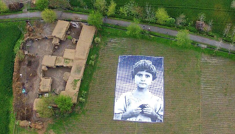 Aktion gegen Drohnenangriffe: In Pakistan haben internationale Künstler auf einem Feld dieses riesige Poster ausgelegt, auf dem ein junges Mädchen ernst in die Kamera blickt. Trauriger Hintergund: Ihre Eltern sind bei einem Drohnenangriff ums Leben gekommmen. Das Bild soll die US-Soldaten, die die Drohnen aus der Ferne steuern, daran erinnern, dass sie mit ihren Anti-Terror-Aktionen Menschen töten. Die Toten, die die Soldaten hinterlassen, nennen sie zynisch "Bug Splat" - Insektenfleck. Entsprechend das Motto der Künstleraktion: "Not A Bug Splat".