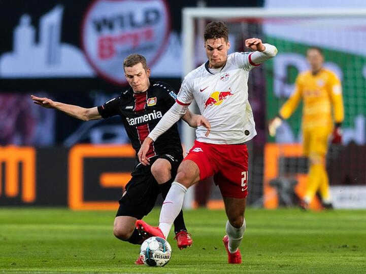 Leverkusens Sven Bender (l) geht gegen Leipzigs Patrik Schick von hinten in den Zweikampf.