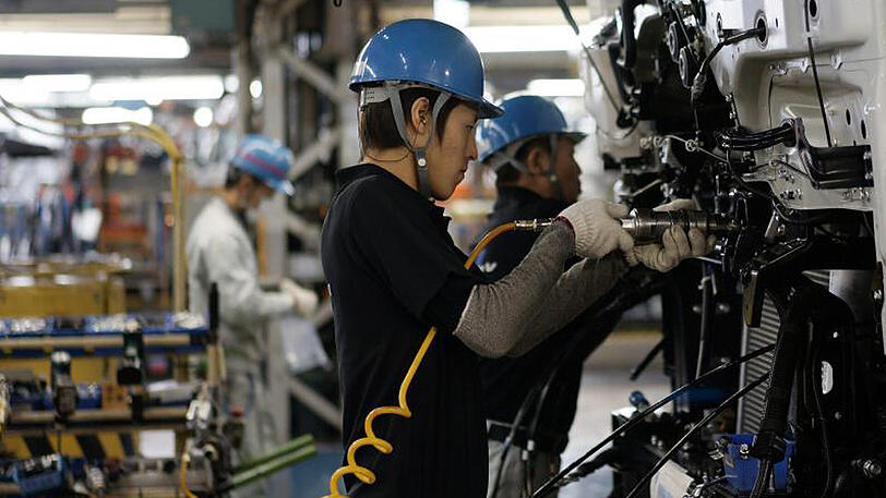 In einem Mitsubishi-Werk im japanischen Kawasaki produzieren Arbeiter Teile für LKW und Busse.
