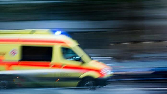 Ein Krankenwagen fährt mit Blaulicht bei einem Einsatz über die Straße.
