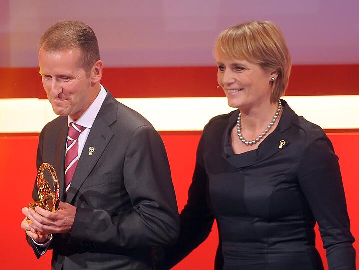 Rennfahrerin Jutta Kleinschmidt überreicht Herbert Diess, Mitglied des Vorstands der BMW, die Auszeichnung für den Wagen BMW X5 in der Kategorie "Sonderklasse SUV". Foto: Britta Pedersen