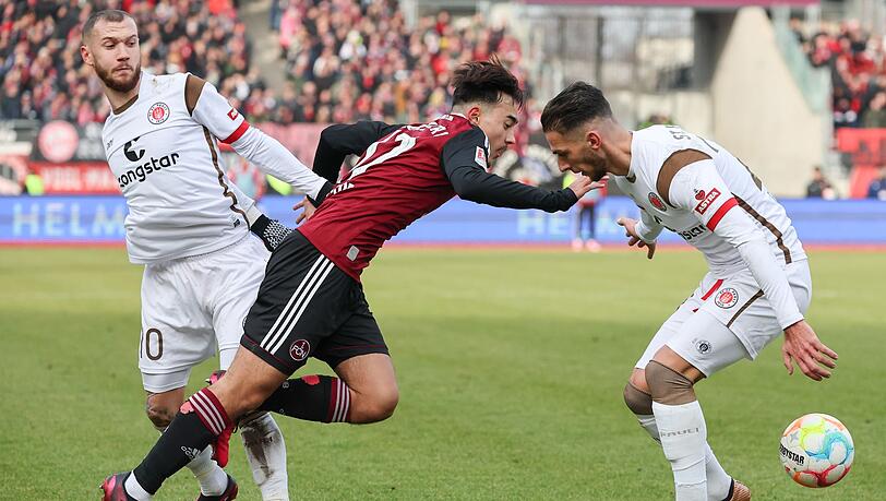 Jens Castrop (M) kämpft mit Marcel Hartel (l) und Leart Paqarada von St. Pauli um den Ball.