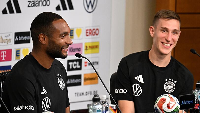 Nico Schlotterbeck und Jonathan Tah lachen w&auml;hrend einer PK.