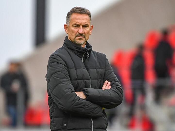 Achim Beierlorzer, Trainer von Regensburg, steht vor dem Spiel im Stadion. Foto: Armin Weigel/Archivbild