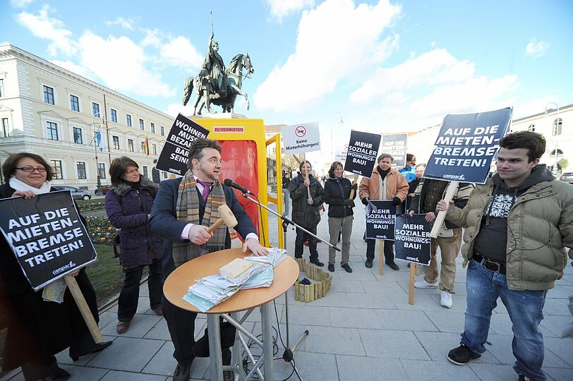 Mit der Versteigerung einer Telefonzelle als "Wohnraum" haben Aktivisten auf dem Odeonsplatz gegen die hohen Mieten in München demonstriert.